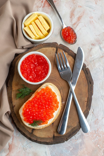 Draufsicht Kaviar-Sandwiches mit Besteck und Käse auf Schneidebrett auf heller Oberfläche