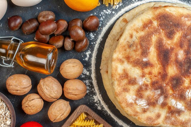 Draufsicht köstliche Flapjacks mit verschiedenen Zutaten Gewürze und Nudeln auf dunklem Hintergrund Brötchen Mahlzeit Farbe Lebensmittel Nussgericht Brot