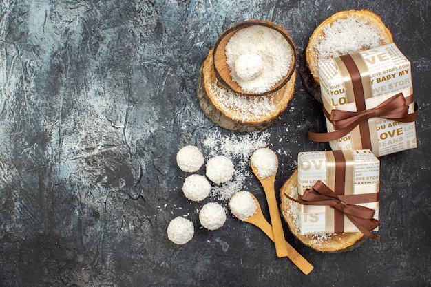 Draufsicht köstliche Kokosbonbons mit Holzstücken auf dunklem Hintergrund Teefrucht-Farbfoto-Goodie