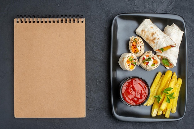 Draufsicht köstliches shaurma geschnittenes Pita-Sandwich mit Pommes frites und Ketchup auf dunkler Oberfläche Burger Essen Mahlzeit Grill Brot Fastfood Toast