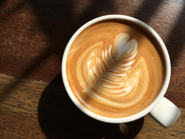 Draufsicht latte art kaffee auf holztisch am morgen