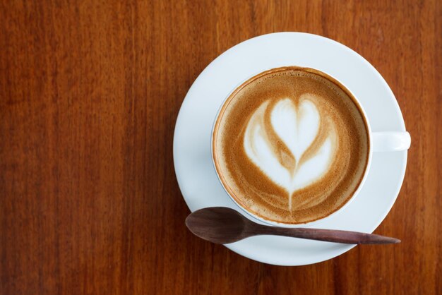 Draufsicht Latte Art Kaffee auf Holztisch