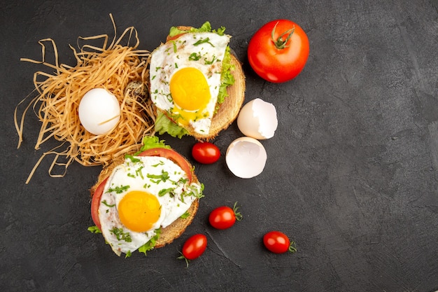 Draufsicht leckere Eiersandwiches mit Tomaten auf dunklem Hintergrund Foto Essen Mahlzeit Frühstück Tierfarben Morgen Tee Salat