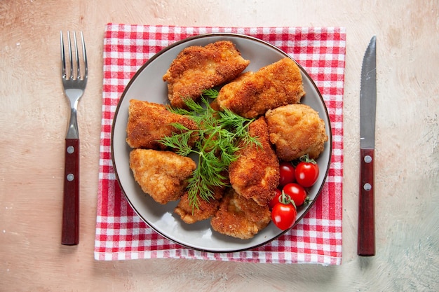 Draufsicht leckere Hähnchenflügel mit Grüns und Tomaten auf hellem Hintergrund Abendessen Fleischessen Mittagessen Pommes Burger Mahlzeit Sandwich