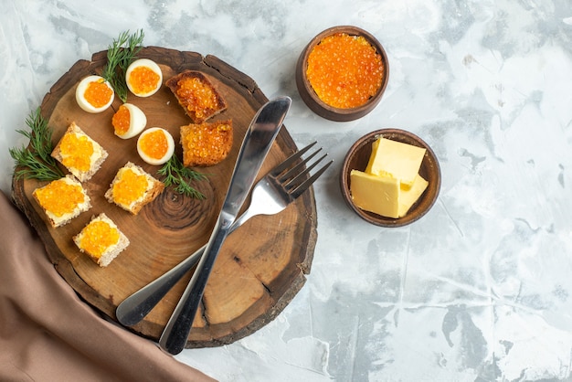 Draufsicht leckere Kaviar-Sandwiches mit gekochten Eiern und Besteck auf Holzbrett weißer Hintergrund Frühstück Fisch Mittagessen Toast Essen Meeresfrüchte