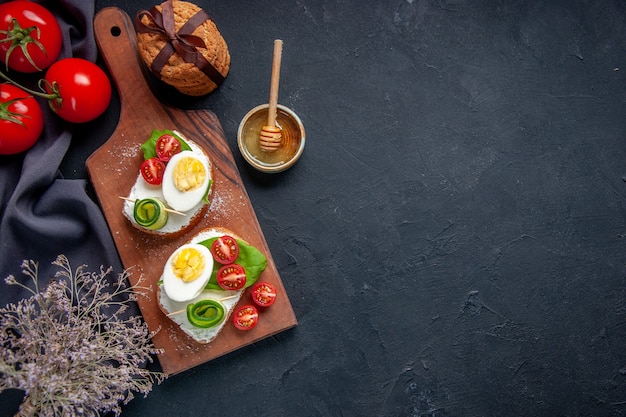 Draufsicht leckere Sandwiches mit Tomaten und Eiern auf Schneidebrett dunkler Hintergrund Toast Snack Burger Sandwich Mittagessen Essen Brot Mahlzeit