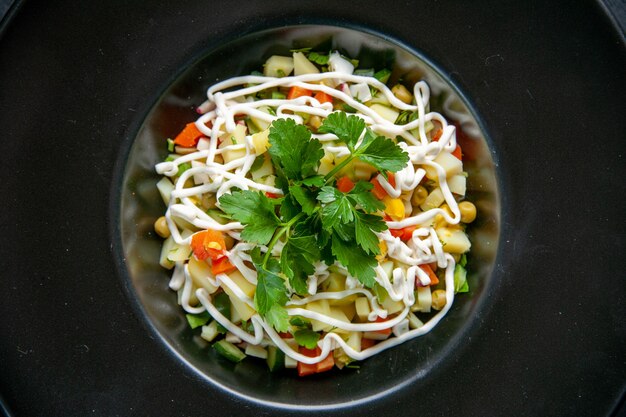 Draufsicht leckerer Kartoffelsalat dekoriert mit grünem Blatt und Mayyonaise im Inneren des Tellers dunkles Oberflächenessen Abendessen Mittagessen Mahlzeit Brotfarbe