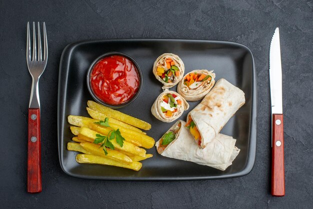 Draufsicht leckeres shaurma geschnittenes pita-sandwich mit pommes frites und ketchup auf dunkler oberfläche burger essen fast-food-mahlzeit grill brot snack toast