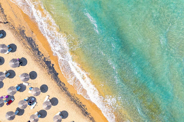 Draufsicht Luftdrohnenfoto des Bananenstrandes mit wunderschönen türkisfarbenen Meereswellen und Strohschirmen Urlaubsreisen Hintergrund Ionisches Meer Insel Zakynthos Griechenland