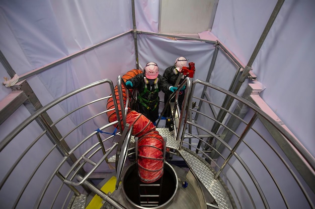 Draufsicht Männchen steigen die Treppe hinauf in den Sicherheitsgebläse-Sicherheitsgebläse-Frischluftbereich des Tanks aus rostfreiem Chemikalienbereich