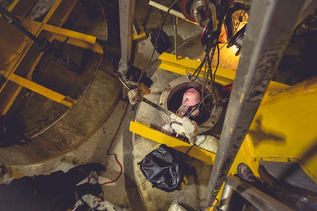 Draufsicht männlich klettern die Treppe hinauf in den rostfreien Chemikalienbereich des Tanks beengten Raum retten Leben mit Rettungsseilsicherheit