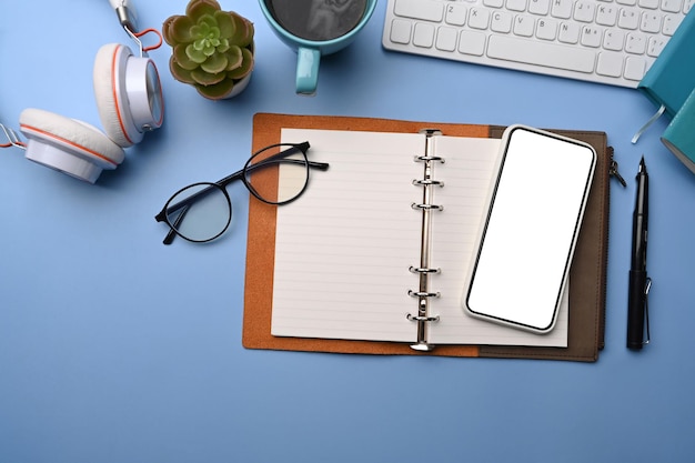 Draufsicht mock-up handybrille notebook und kaffeetasse auf blauem hintergrund