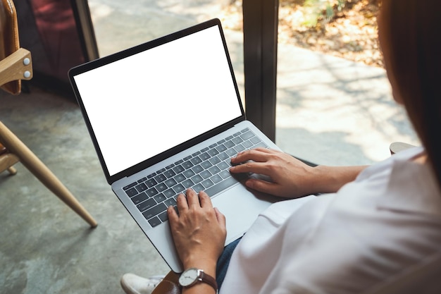 Draufsicht-Modellbild einer Frau, die Laptop-Computer mit leerem weißem Desktop-Bildschirm verwendet und tippt