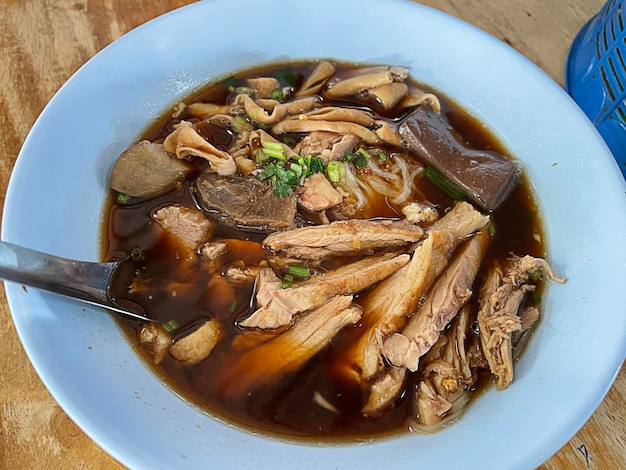 Foto draufsicht nudelsuppe geschmorte ente auf holztisch