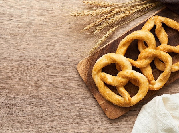 Draufsicht oder flache Laiengruppe Brezel in Holzplatte auf Holztisch über dem Hintergrund.