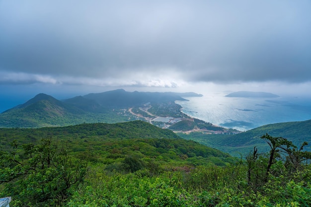 Draufsicht Panoramablick auf die Küste der Insel Con Dao von oben mit Wellen, Küste, klarem Himmel und Straße, blauem Meer und Bergen. Neuer Passagierhafen von Con Dao