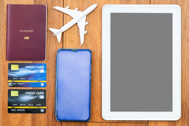 Draufsicht Pass mit Kreditkarte und digitaler Tablette verspotten oben auf hölzernem Schreibtisch