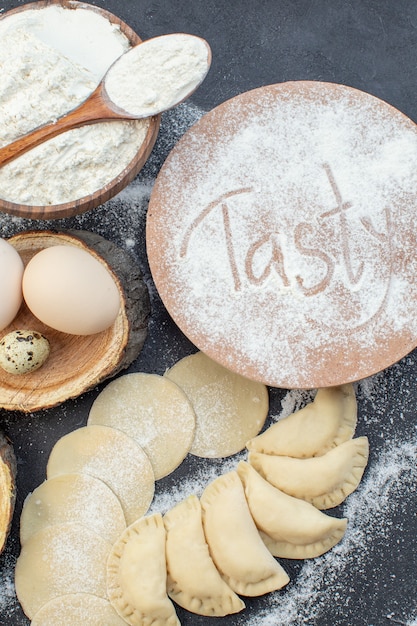 Draufsicht rohe Kartoffel-Hotcakes mit Eiern Kartoffelpüree und Mehl auf dunklem Hintergrund Mahlzeit Pie Keks Ofenkuchen backen Teig lecker kochen