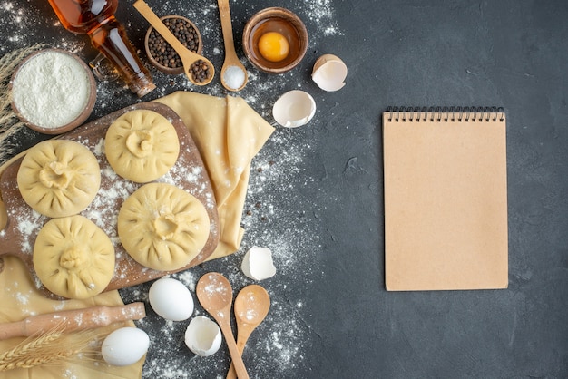 Draufsicht rohe Knödel über Schneidebrett mit Mehl und Eiern