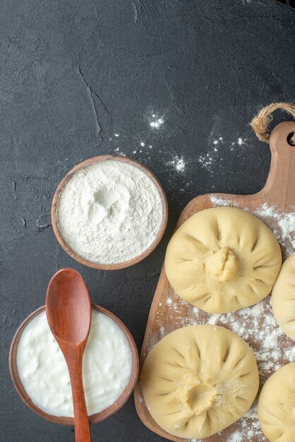 Draufsicht rohe Knödel über Schneidebrett mit Mehl