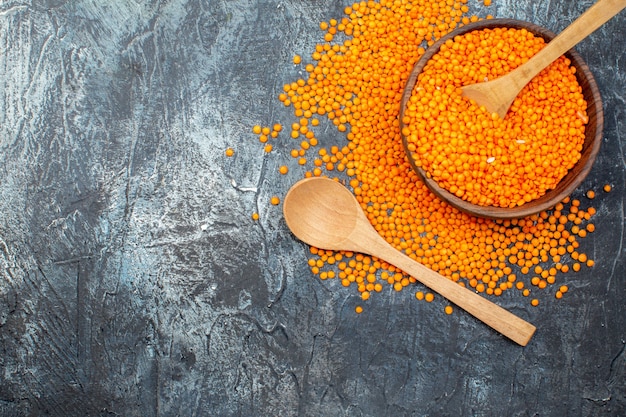 Draufsicht rohe orange Linsen im Teller auf hellgrauem Hintergrund Foto Mahlzeit Farbe Abendessen Gemüsegericht Pfeffer Küche Pflanze