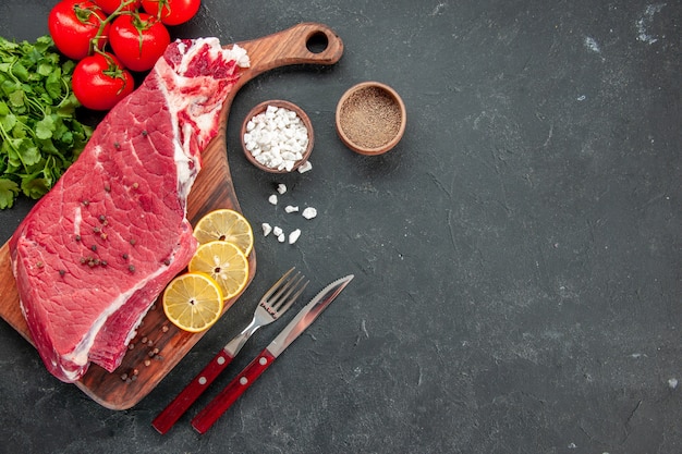 Draufsicht rohes Fleischscheibe mit roten Tomaten und Grüns