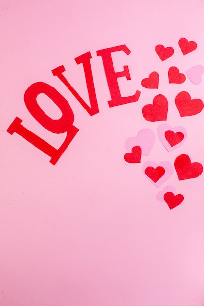 Draufsicht rotes Herz Aufkleber Liebe in Großbuchstaben auf rosa Hintergrund kopieren Platz