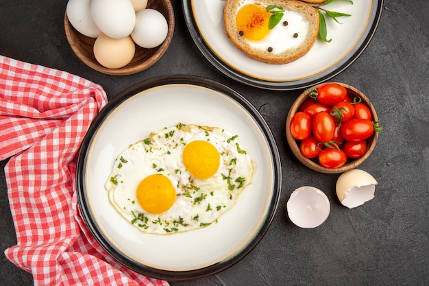 Draufsicht Rührei mit Toast und Tomaten auf dunklem Hintergrund Brot Omelette Essen Frühstück Mittagessen Tee Mahlzeit Morgen