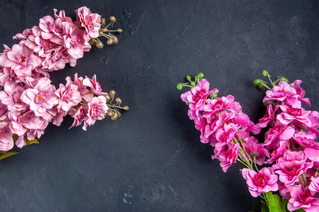 Draufsicht schöne rosa Blumen auf dunkler Oberfläche