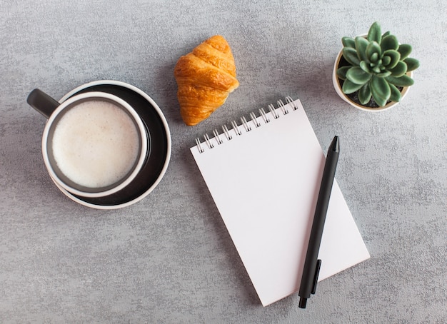 Draufsicht Schreibtisch mit Notizbuch und Tasse Kaffee