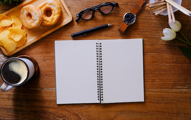 Draufsicht Smartphone Kaffeetasse Gläser Schreibwaren und Donuts auf Holztisch Flay latx9