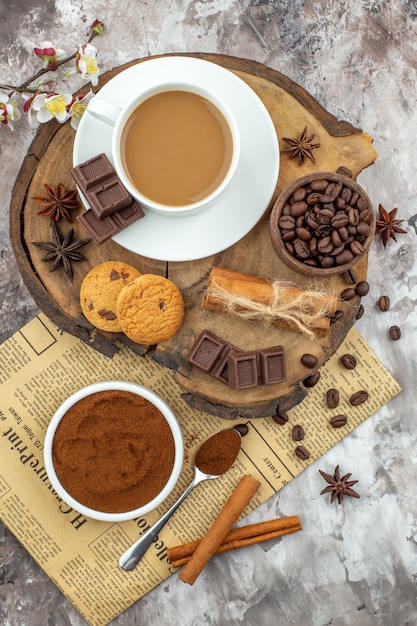 Draufsicht Tasse Kaffeekekse Schüssel mit Kaffeebohnen Schokoladen-Zimt-Sticks mit Seil-Anis-Sternen auf Holzbrett auf dem Tisch gebunden