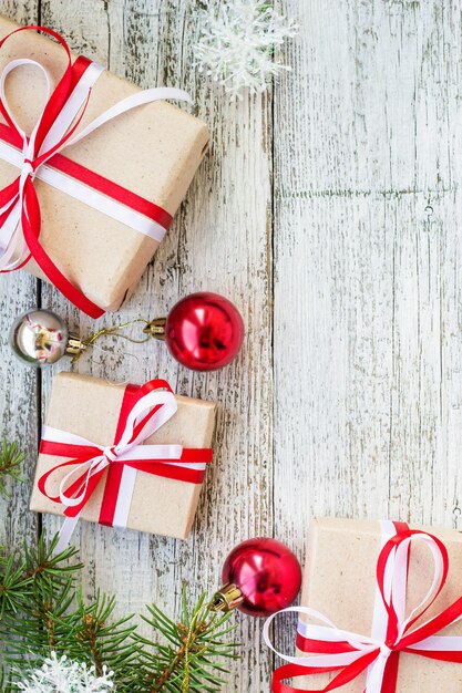 Draufsicht über Rahmen von den Weihnachtsdekorationen, Geschenkboxen, Tannenzweige auf der weißen Holzoberfläche mit Kopienraum