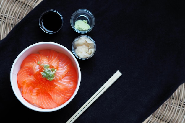 Draufsicht und Fokus auf Lachs mit japanischem Reis oder Lachs Ikura Don in Papierschale