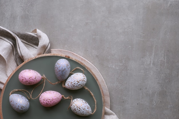 Draufsicht von dekorativen handgemachten Ostereiern in den Pastellfarben auf hölzernem Behälter