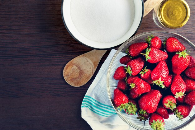 Draufsicht von frischen Erdbeeren und von Zucker. Erdbeermarmeladenbestandteile vorbereitet gekocht zu werden.