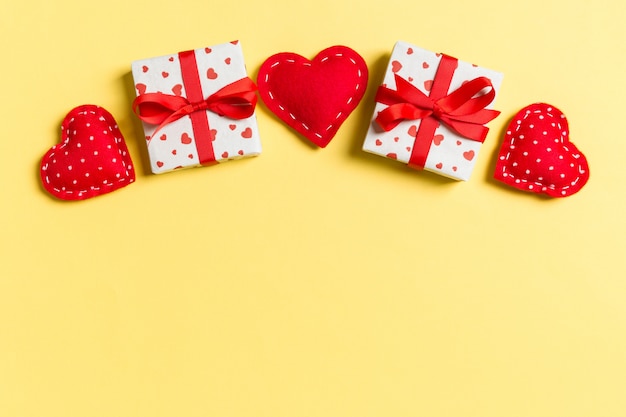 Draufsicht von Geschenkboxen und von roten Textilherzen. Valentinstagkonzept mit Kopienraum