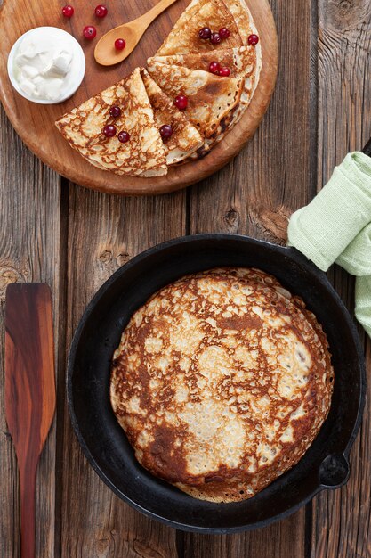 Draufsicht von köstlichen selbst gemachten Pfannkuchen mit Sauerrahm und Beeren