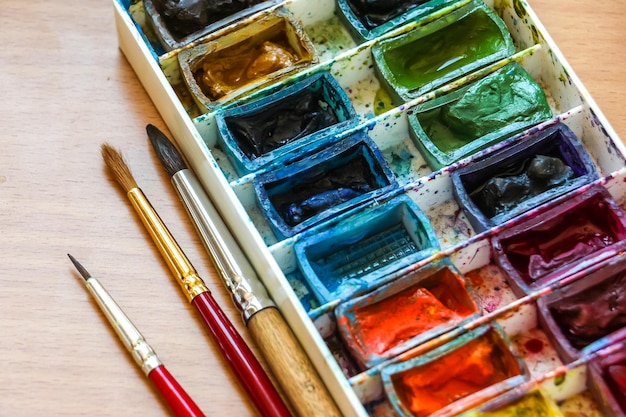 Draufsicht von Malerpinselpaletten- und -aquarellfarben