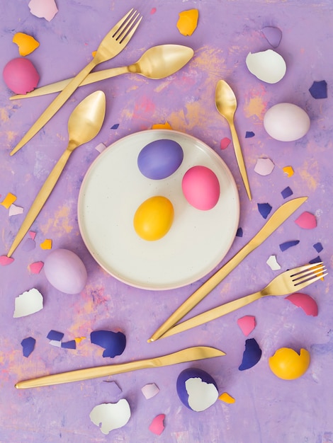 Draufsicht von verschiedenen farbigen Eiern und von zerstreuter Eierschale auf abstraktem Hintergrund.
