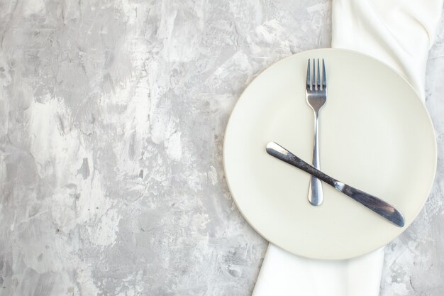 Draufsicht weißer Teller mit Gabel und Messer auf hellem Hintergrund Küche Lebensmittelfarbe Mahlzeit horizontale Damen Glas