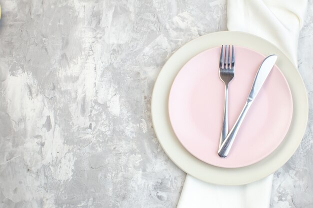 Draufsicht weißer Teller mit rosa Teller und Besteck auf heller Oberfläche Küche Glas Essen Mahlzeit Weiblichkeit horizontale Farbe Damen