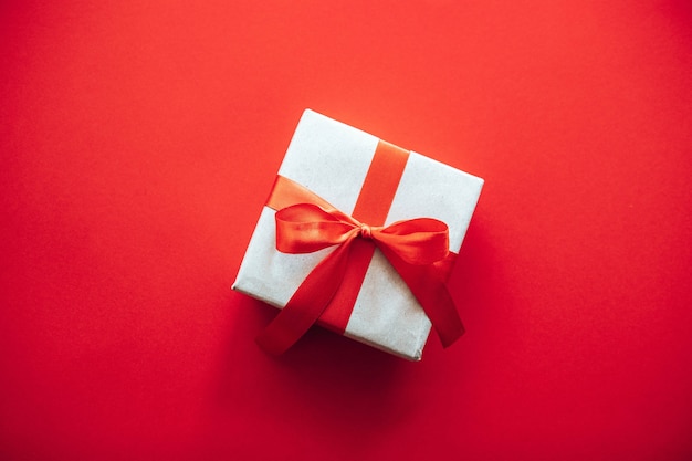 Draufsicht Zusammensetzung der Weihnachtsgeschenkbox eingewickelt in Bastelpapier mit roter Schleife