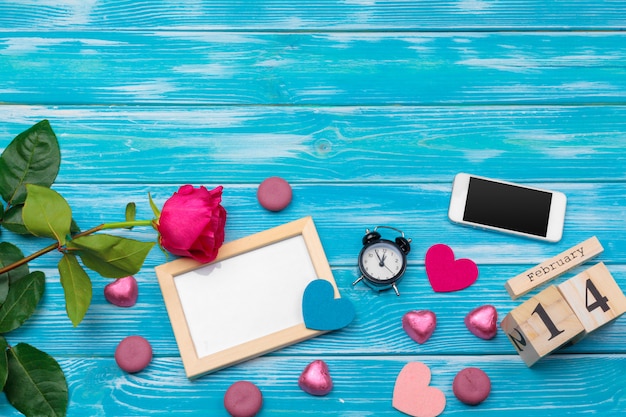 Draufsichtliebesfeiertagsfeier kreative Valentine Day-romantische Zusammensetzungsebenenlage roter Herzkalender-Datumsblauer hölzerner Hintergrund