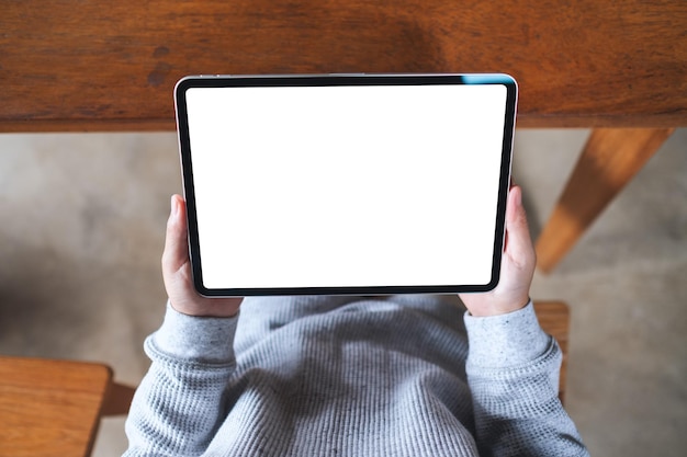 Draufsichtmodell einer Frau, die ein digitales Tablet mit einem leeren weißen Desktop-Bildschirm hält