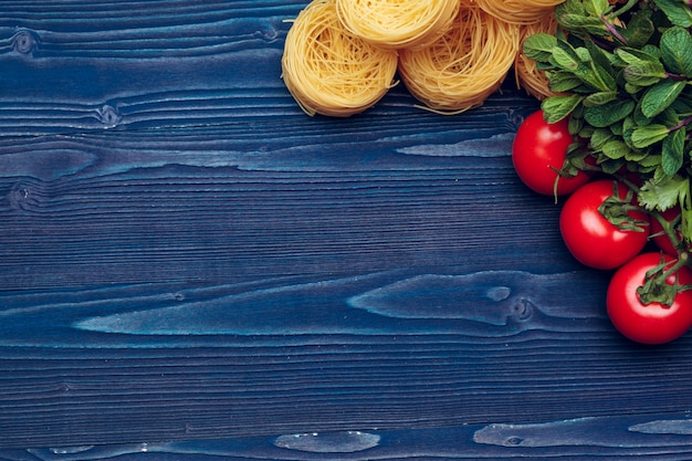 Draufsichtnahaufnahmedetail von italienischen Teigwaren der Bandnudeln auf hölzernem blauem Hintergrund