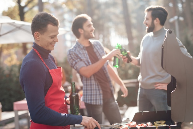 Draußen kocht ein mann grillgut.