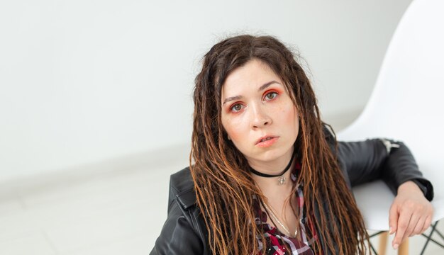 Dreadlocks, cabeleireiro e conceito de estilo - Uma garota estilosa com dreadlocks e em jaqueta de couro e maquiagem da moda, copie espaço