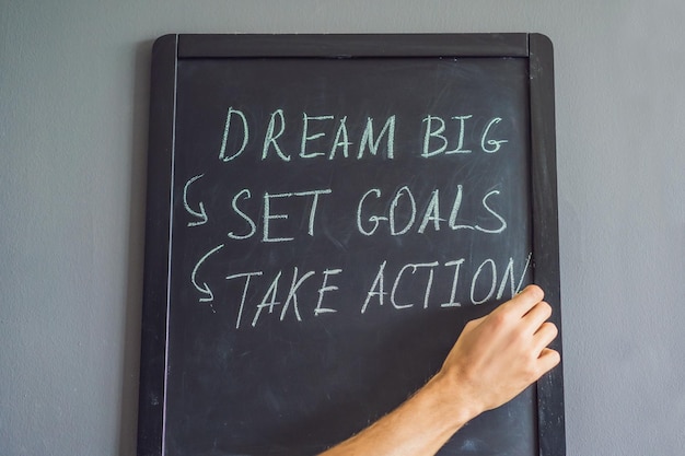 Dream Big Set Goal Take Action Handschrift auf einer Kreidetafel