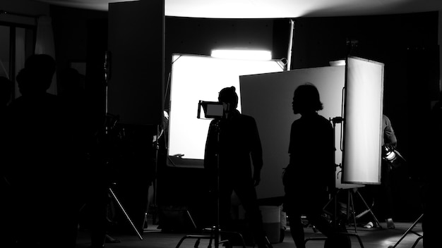 Foto drehstudio hinter den kulissen in silhouettenbildern, das team der filmcrew arbeitet für die dreharbeiten zu filmen